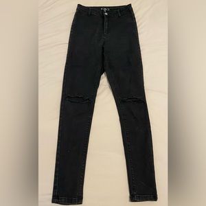 High waisted black skinny jeans with knee rips and stretchy denim